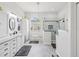 Bright bathroom features glass shower, storage, vanity, and tile floors at 18845 Fairway Green Dr, Hudson, FL 34667