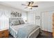 Cozy bedroom featuring a queen size bed with decorative pillows, ceiling fan, and wood-look floors at 18845 Fairway Green Dr, Hudson, FL 34667