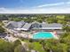 Aerial view of the clubhouse and outdoor pool with lounge chairs surrounded by manicured landscaping at 18845 Fairway Green Dr, Hudson, FL 34667