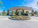 Entrance to Heritage Pines gated community with lush landscaping and a decorative island at 18845 Fairway Green Dr, Hudson, FL 34667