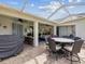 Inviting covered patio with brick flooring, an outdoor dining table, and comfortable seating arrangements at 18845 Fairway Green Dr, Hudson, FL 34667