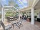 Spacious covered patio features an outdoor dining area and a cozy lounge area with comfortable seating at 18845 Fairway Green Dr, Hudson, FL 34667