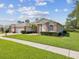 Charming single-story home with a well-manicured lawn, brick accents, three-car garage and a brick paver driveway at 18845 Fairway Green Dr, Hudson, FL 34667