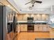 Kitchen with stainless steel appliances, light wood cabinets, black countertops, and ample storage space at 18845 Fairway Green Dr, Hudson, FL 34667