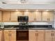 Close-up of kitchen cabinets and appliances, with black countertop and decorative details at 18845 Fairway Green Dr, Hudson, FL 34667