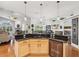 Kitchen island with bar seating, stainless steel dishwasher, and views of the open-concept living and dining area at 18845 Fairway Green Dr, Hudson, FL 34667