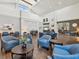 Bright lounge with vaulted ceilings and comfortable blue armchairs at 18845 Fairway Green Dr, Hudson, FL 34667