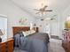 Bright main bedroom featuring neutral walls, ceiling fan, and wood furnishings at 18845 Fairway Green Dr, Hudson, FL 34667