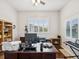 Bright home office with a large wooden desk, built-in shelves, and electric fireplace at 18845 Fairway Green Dr, Hudson, FL 34667