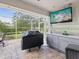Screened outdoor kitchen featuring a granite countertop, sink, and TV, great for entertaining at 18845 Fairway Green Dr, Hudson, FL 34667