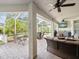 Inviting covered patio with comfortable seating, ceiling fans, a flat screen television, and outdoor kitchen at 18845 Fairway Green Dr, Hudson, FL 34667