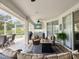 Covered patio area with comfortable seating, a fire pit, ceiling fan, and outdoor kitchen at 18845 Fairway Green Dr, Hudson, FL 34667