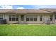 View of the back of the property showcasing the grassy backyard, building structure, and many windows at 2165 Springmeadow Dr, Spring Hill, FL 34606