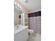 Bathroom featuring sink and vanity, toilet, and shower with patterned shower curtain at 2165 Springmeadow Dr, Spring Hill, FL 34606