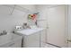 Bright laundry room featuring a sink, washer, dryer, storage, and tile flooring at 2165 Springmeadow Dr, Spring Hill, FL 34606