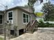 Back of the home showing access stairs, exterior details, and yard features at 221 Highland St, Brooksville, FL 34601