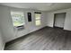 This bedroom has two windows, updated flooring, and a wall air conditioning unit at 221 Highland St, Brooksville, FL 34601