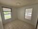 A bright bedroom with tiled floors and multiple windows offering views of the exterior at 221 Highland St, Brooksville, FL 34601