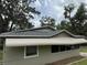 Side view showcasing the awning, windows, and roofline of this quaint home at 221 Highland St, Brooksville, FL 34601