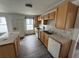 A kitchen featuring wooden cabinets, tile backsplash and countertops, a white dishwasher and stove, and gray wood-look floors at 221 Highland St, Brooksville, FL 34601