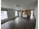 An open-concept living area featuring gray wood-look floors, a kitchen, a kitchen island, and lots of natural light at 221 Highland St, Brooksville, FL 34601