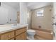 Bathroom featuring a tile bathtub, vanity with sink and mirror, and a toilet at 2450 Ambassador Ave, Spring Hill, FL 34609