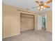 Neutral bedroom showing a closet with bar, carpet, ceiling fan, and a doorway at 2450 Ambassador Ave, Spring Hill, FL 34609