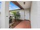 Inviting front porch with decorative palm trees, and a red-tiled walkway at 2450 Ambassador Ave, Spring Hill, FL 34609