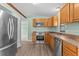 Updated kitchen with stainless steel appliances, wood cabinets, and wood-look flooring at 2450 Ambassador Ave, Spring Hill, FL 34609