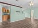 Open-concept living room featuring stylish wood flooring and a view into the kitchen at 2450 Ambassador Ave, Spring Hill, FL 34609