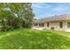View of the backyard with a lush green lawn and mature trees at 2481 Whispering Pines Ct, Spring Hill, FL 34606