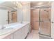 Bathroom featuring dual sinks, a large mirror, and a shower with glass doors at 2481 Whispering Pines Ct, Spring Hill, FL 34606