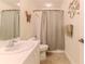 Bathroom features a white sink, shower with a curtain, and decorative accents at 2481 Whispering Pines Ct, Spring Hill, FL 34606