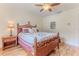 Bedroom boasts a wood-framed bed, nightstand, ceiling fan, and artwork at 2481 Whispering Pines Ct, Spring Hill, FL 34606