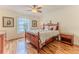 Bedroom features a wood-framed bed, matching nightstand, and a window at 2481 Whispering Pines Ct, Spring Hill, FL 34606