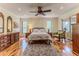 Bedroom with hardwood floors, a ceiling fan, an armchair, and natural lighting at 2481 Whispering Pines Ct, Spring Hill, FL 34606