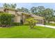 Charming single-story home featuring a well-maintained lawn, mature trees, and a screened garage at 2481 Whispering Pines Ct, Spring Hill, FL 34606