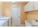Bright laundry room featuring cabinets, a utility sink, and a washer and dryer at 2481 Whispering Pines Ct, Spring Hill, FL 34606