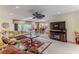 Spacious living room featuring a ceiling fan, comfortable sofas, and a large flat-screen television at 2481 Whispering Pines Ct, Spring Hill, FL 34606