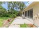 View of the outdoor patio of the property with chairs and greenery at 2481 Whispering Pines Ct, Spring Hill, FL 34606