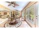 Bright sunroom with a glass-topped table, seating area, and views of backyard at 2481 Whispering Pines Ct, Spring Hill, FL 34606