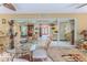 Bright sunroom features tile flooring, a glass table and sliding glass doors at 2481 Whispering Pines Ct, Spring Hill, FL 34606