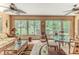 Bright sunroom with glass-topped table, seating area, and backyard views at 2481 Whispering Pines Ct, Spring Hill, FL 34606