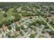 An aerial view shows a golf course community and a suburban neighborhood with tree lined streets and landscaping at 2486 Deer Trail Ln, Spring Hill, FL 34606