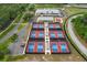 Aerial view showcasing community tennis courts, a parking lot, and a clubhouse at 2486 Deer Trail Ln, Spring Hill, FL 34606