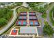 Aerial view of tennis courts, basketball court, and clubhouse with ample parking spaces at 2486 Deer Trail Ln, Spring Hill, FL 34606