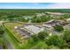 Aerial view showcasing the community center with parking, tennis courts and surrounding landscape at 2486 Deer Trail Ln, Spring Hill, FL 34606