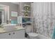This bathroom features a stylishly decorated corner shelf, a white sink, and granite counters at 2486 Deer Trail Ln, Spring Hill, FL 34606