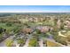 Aerial view of the clubhouse with lush landscaping, a golf course, and ample parking at 2486 Deer Trail Ln, Spring Hill, FL 34606
