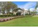 Stunning clubhouse featuring a covered entrance, beautiful landscaping and manicured lawn at 2486 Deer Trail Ln, Spring Hill, FL 34606